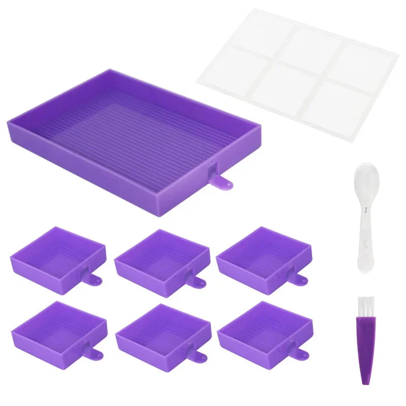 Paarse set van zes vierkante diamond painting bakjes met groot sorteervak, transparant deksel, lepel en schoonmaakborsteltje op witte achtergrond