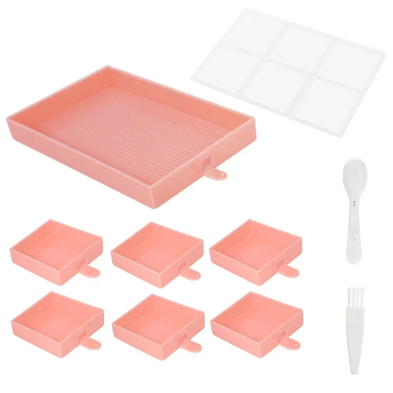Roze set met zes vierkante diamond painting bakjes, inclusief groot sorteerbakje, transparant deksel, lepel en wit schoonmaakborsteltje op witte achtergrond