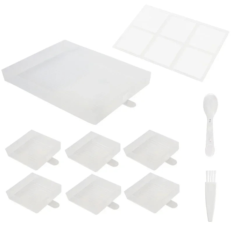 Transparant witte set van zes vierkante diamond painting bakjes met groot sorteerbakje, deksel, witte lepel en schoonmaakborsteltje op witte achtergrond